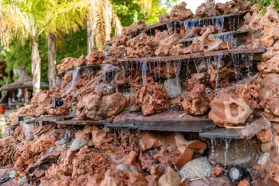 a rock wall with water dripping from it at Domaine Alma Marrakech in Marrakech
