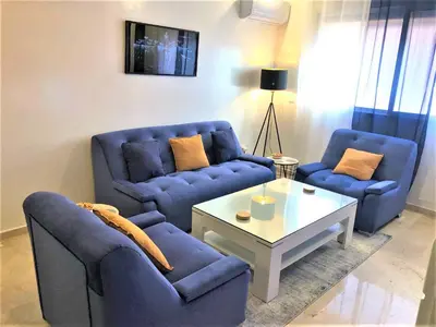 a living room with two blue chairs and a coffee table at SUPER APPART Marrakech - Confort Propreté Proximité in Marrakech