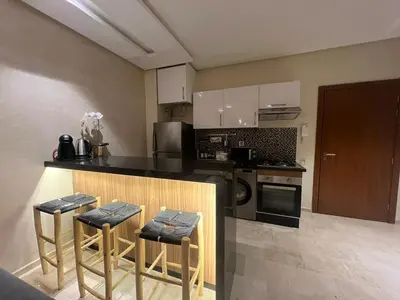 a kitchen with a counter and some stools in it at Studio sur golfe et piscine in Marrakech
