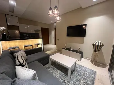 a living room with a couch and a table at Studio sur golfe et piscine in Marrakech