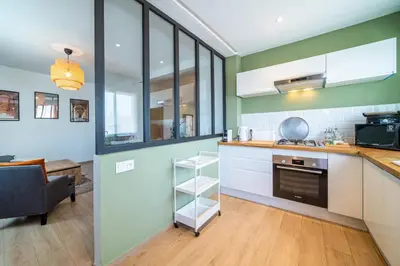 a kitchen with green walls and white cabinets at Perle Rare à Bab Ighli Marrakech in Marrakech