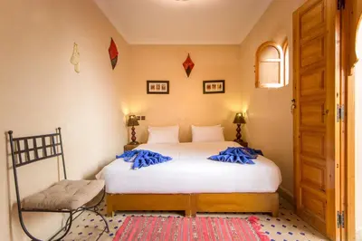 a bedroom with a bed with blue pillows on it at Riad Colette EXCLUSIF - Médina - Breakfast - Wifi in Marrakech