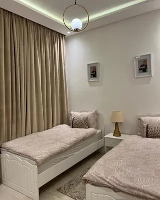 a bedroom with two beds and a window with curtains at Dar Sanaa Marrakech in Marrakech