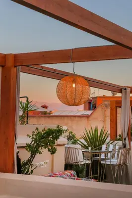 a chandelier hanging over a table and chairs on a balcony at Riad Kahena in Marrakech