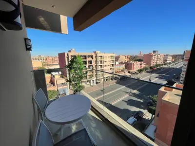 a balcony with a table and a view of a street at NEW SUPER LUXURY APARTMENT (CENTRAL MARRAKECH) in Marrakech