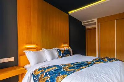 a bedroom with a large white bed with wooden walls at AppartHotel Atrani in Marrakech