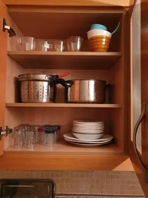 a kitchen cabinet filled with pots and pans and plates at Atlas golf in Marrakech
