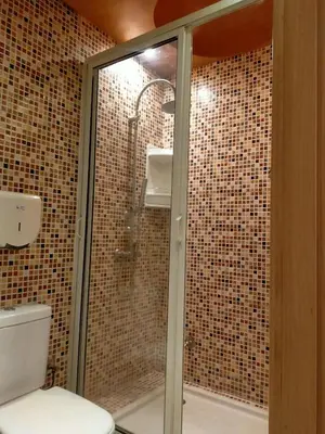 a bathroom with a glass shower with a toilet at Firdaouss apartment in Marrakech