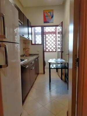a kitchen with a table in the middle of it at Firdaouss apartment in Marrakech