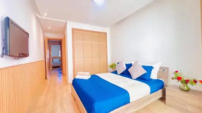 a bedroom with a large bed and a flat screen tv at Prestigia Appartement de luxe in Marrakech