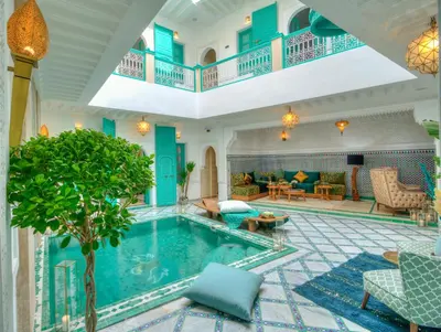 a pool in the middle of a room with a living room at riad paradis blanc in Marrakech