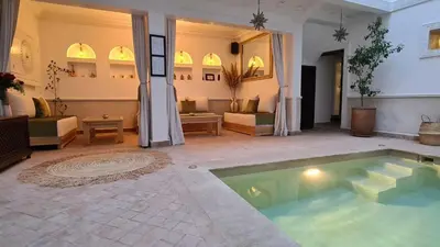 a swimming pool in a room with a living room at Riad Alizé in Marrakech