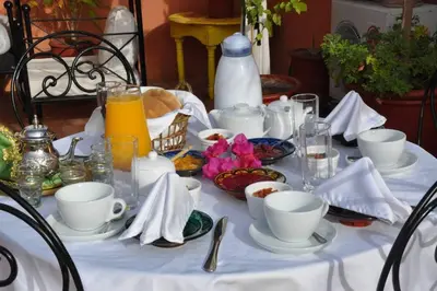 a table with white cups and saucers on it at Riad Bonheur in Marrakech