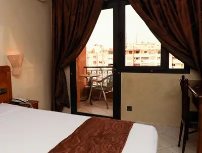 a bedroom with a bed and a view of a balcony at Hotel Majorelle in Marrakech