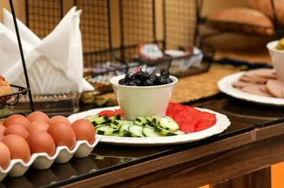 a table with a plate of fruit and eggs on it at Hotel Majorelle in Marrakech