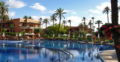 a large swimming pool in front of a resort at Palmeraie Village in Marrakech