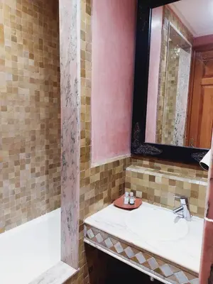 a bathroom with a sink and a tub and a mirror at Palmeraie Village in Marrakech