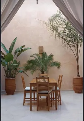 a dining room with a table and chairs and plants at Riad L'Aéroport in Marrakech