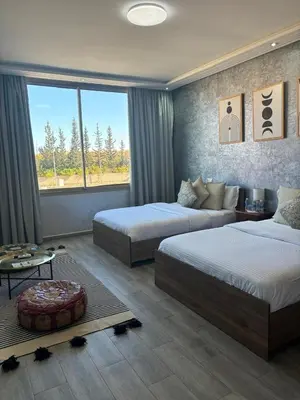 a hotel room with two beds and a window at Riad L'Aéroport in Marrakech