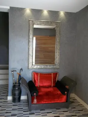 a red chair in a room with a mirror at Villa Firdaous in Marrakech