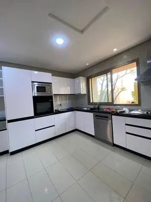 a large kitchen with white cabinets and appliances at Villa Firdaous in Marrakech