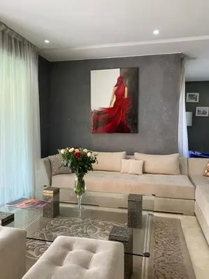 a living room with a couch and a painting of a woman at Villa Firdaous in Marrakech