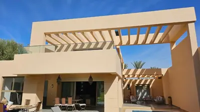 a modern house with a wooden pergola at Villa Firdaous in Marrakech