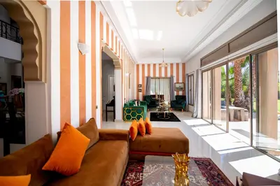 a living room with a brown couch and orange pillows at Villa Cartier in Marrakech