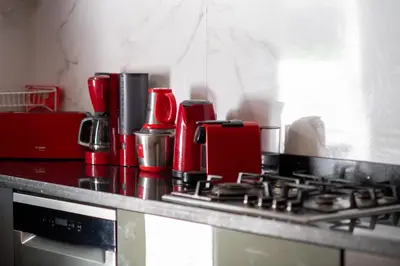 a kitchen counter with a stove with a red appliance at Villa Cartier in Marrakech