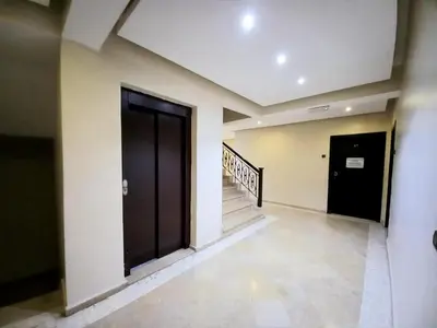 a hallway with a black door and a staircase at Central Aparts Av Prince Moulay Abdellah in Marrakech