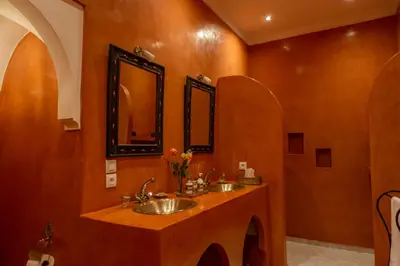 a bathroom with two sinks and a mirror at Riad Dar Talah in Marrakech