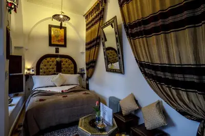 a bedroom with a bed and a mirror and curtains at Room in BB - Riad Anabel - Chocolat Double Room in Marrakech