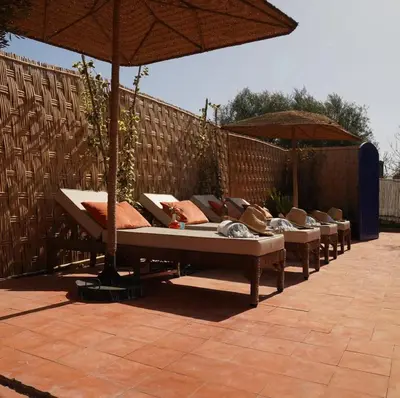 a row of beds with umbrellas on a patio at Beldicolors in Marrakech