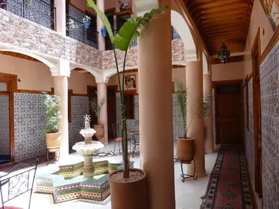a lobby with a palm tree in a building at Hotel imouzzer in Marrakech