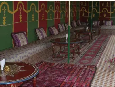 a living room with couches and tables in a room at Hotel imouzzer in Marrakech