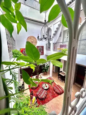 a room with a table with plants and a chandelier at Riad Dar Chadia in Marrakech