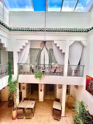 a room with tables and a chandelier in a building at Riad Dar Chadia in Marrakech