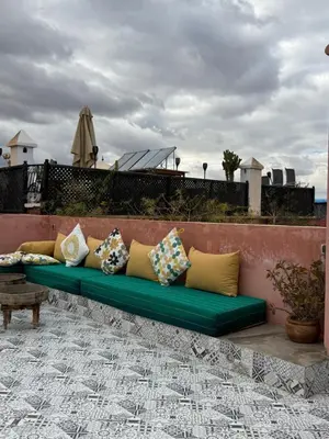 a green couch with pillows sitting on a wall at Riad Dar Chadia in Marrakech