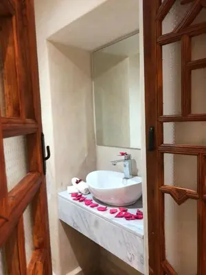 a bathroom with a sink and a mirror at Riad Oscaroi in Marrakech