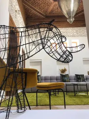 a large metal sculpture in a room with a couch at Riad Oscaroi in Marrakech