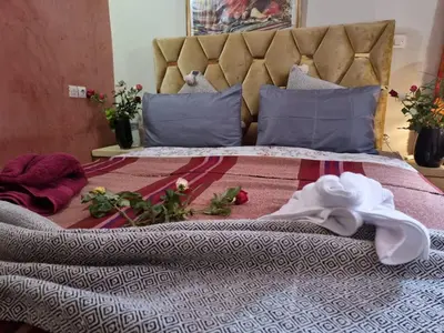 a bed with a headboard and a white towel on it at Casa del Sol Marrakech in Marrakech