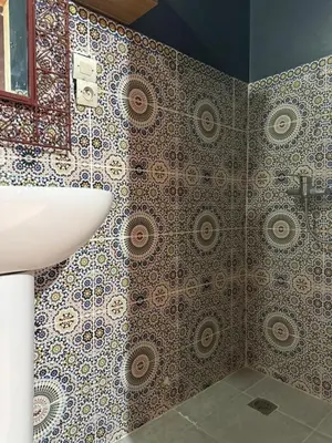 a bathroom with a sink and a mosaic wall at Casa del Sol Marrakech in Marrakech