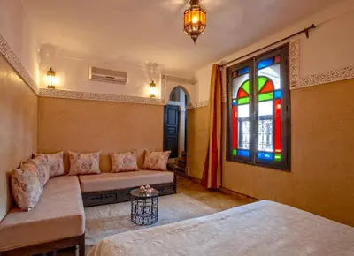 a living room with a couch and a stained glass window at Riad Basim in Marrakech
