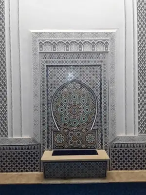 a room with a tile wall with a bench in front at Riad Nouhal in Marrakech