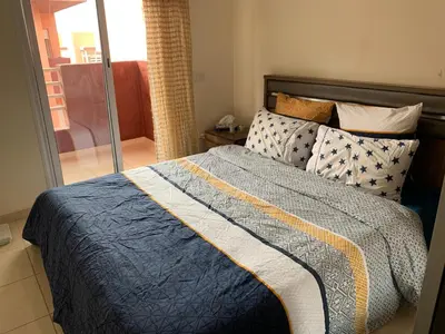 a bed with a blue and yellow blanket and pillows at Appartement zen in Marrakech