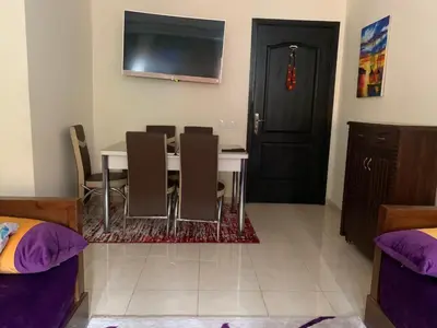 a dining room with a table and chairs and a tv at Appartement zen in Marrakech