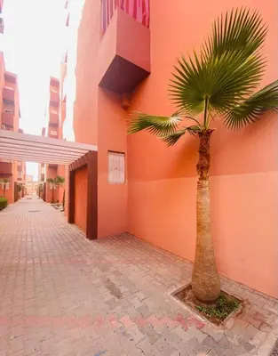 a palm tree in front of a building at Appartement zen in Marrakech