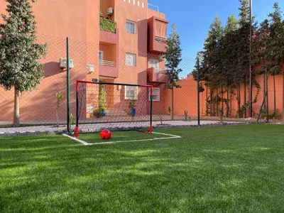 a soccer ball on a field in front of a building at Appartement zen in Marrakech