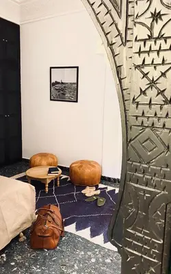 a room with a bed and two ottomans at Riad Ksar Saad & Spa in Marrakech