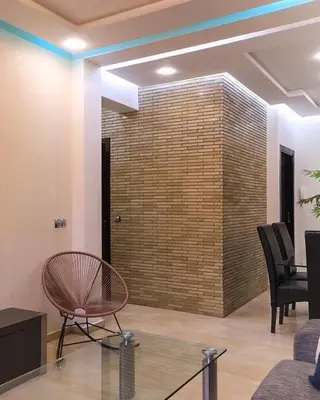 a lobby with a chair and a brick wall at Le soleil de Marrakech in Marrakech